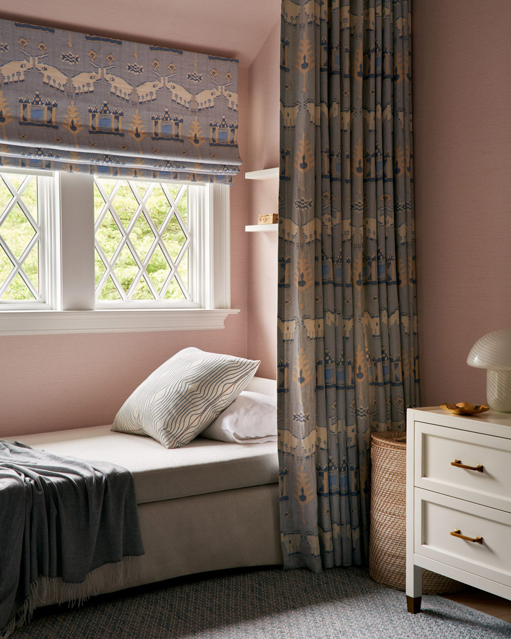 Pink-walled child's room with a curtained daybed reading nook in Southampton house with interiors by Janine Carendi MacMurray or Area Interior Design