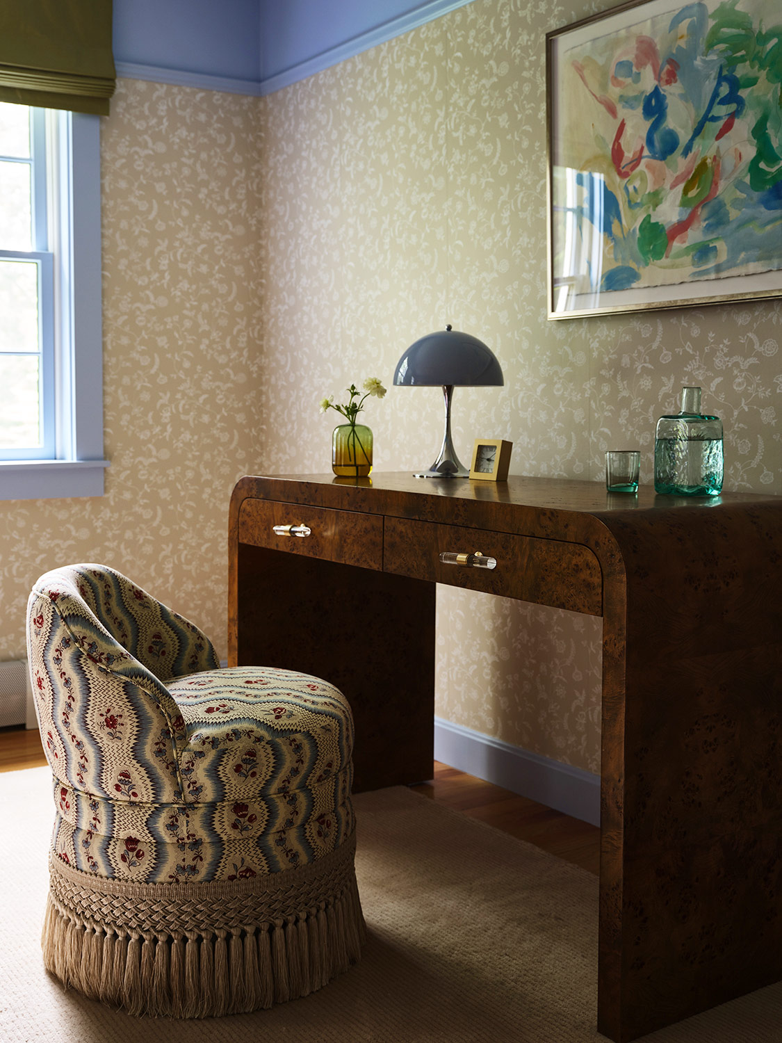 A fringed chair pulls up to a burl-wood desk in one of the guest rooms of a New Hampshire house with interiors by designer Zoe Feldman