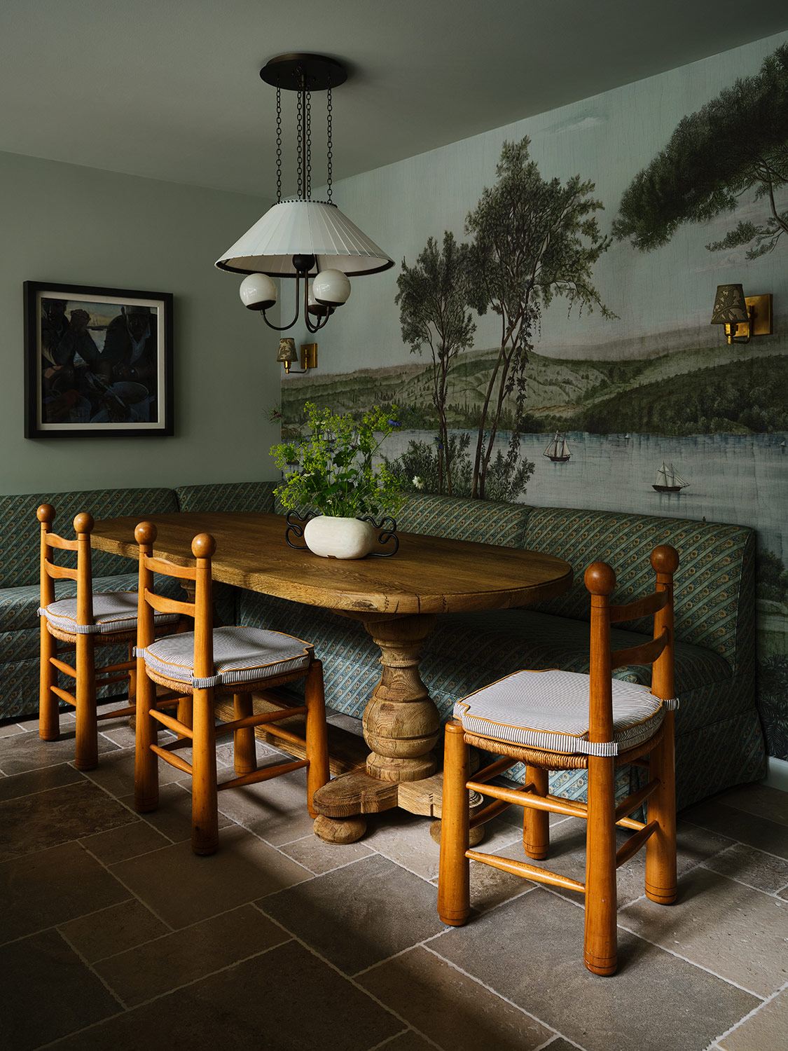 Scenic coastal wallpaper, French trestle table and mid-20th-century wood and woven-rush chairs by Charles Dudouyt in the breakfast nook of a New Hampshire house with interiors by designer Zoe Feldman