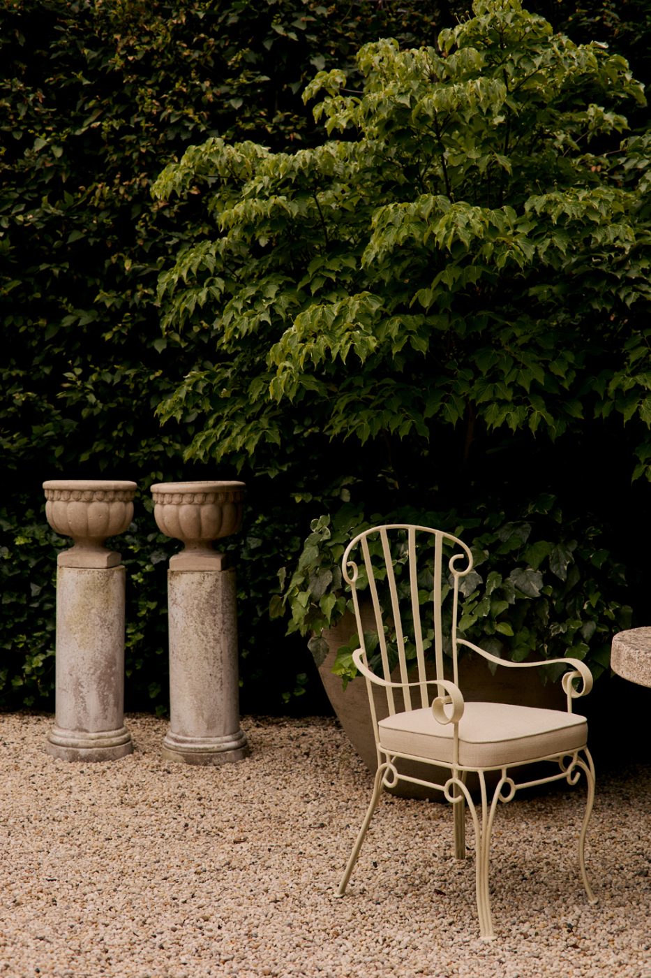 On offer by the gallery Galerie Green a sculptural European wrought-iron chair from the 1950s and neoclassical French urns from the same period