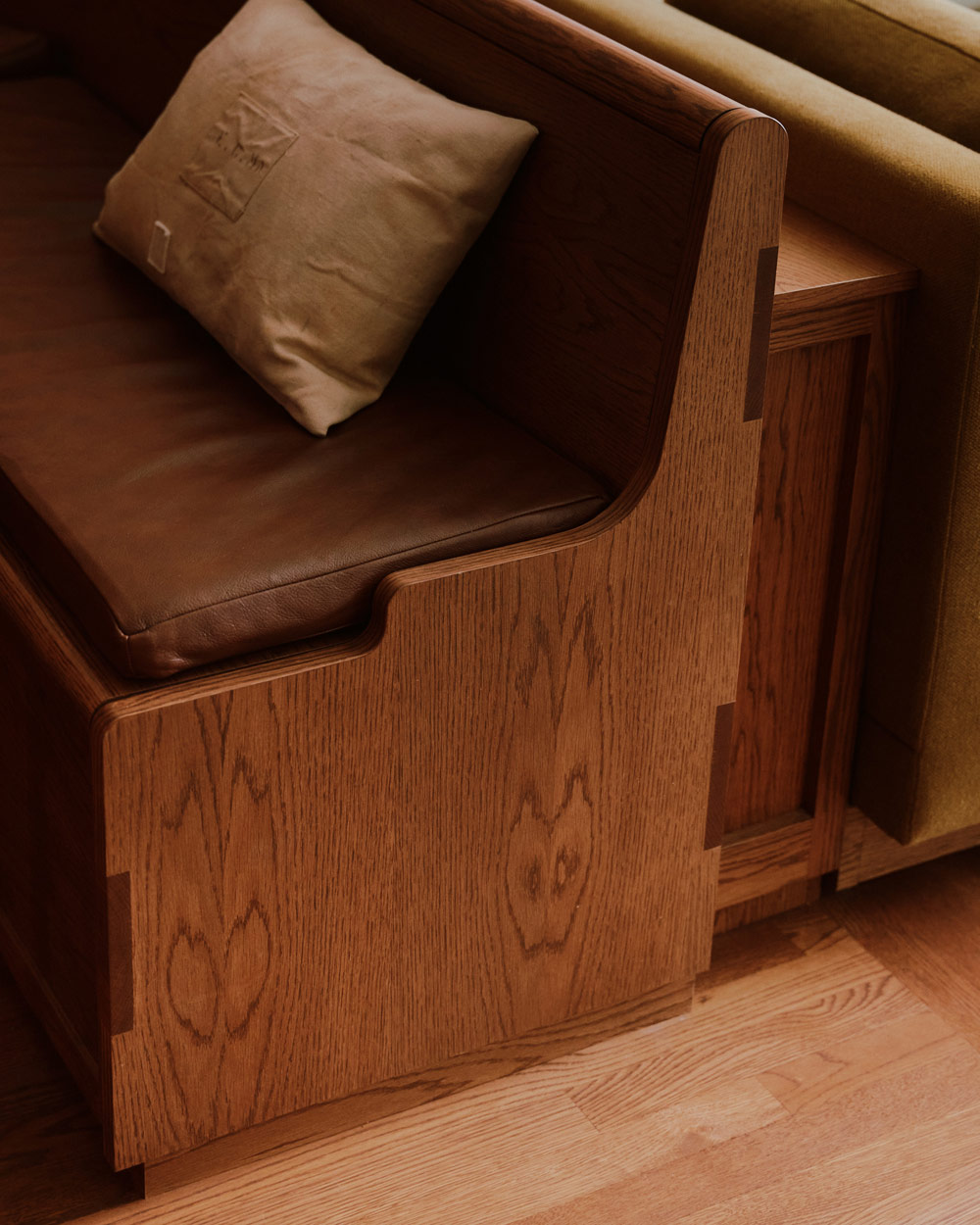 Detail of church pew-like banquette bench connected to back of sofa in a downtown New York loft designed by Sarah Zames and Colin Stief, of the Brooklyn-based studio General Assembly
