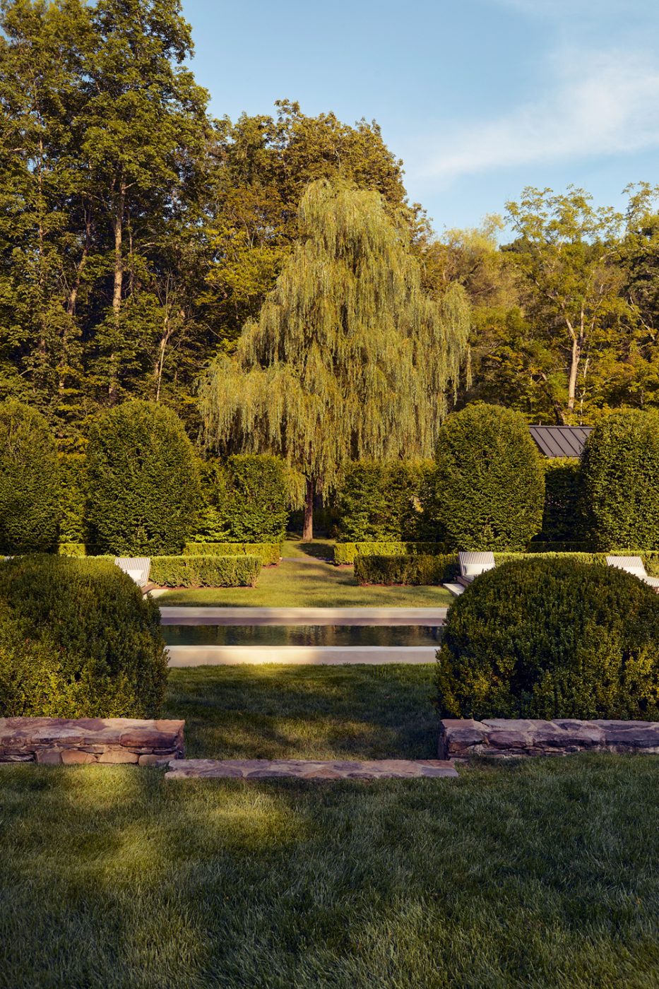 Pool, patio and high hedges at the of Rhinebeck New York Home of Matthew and Casey Fisher, whose landscapes were designed by the Brooklyn studio Harrison Green.