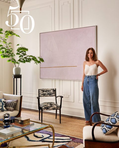 Portrait of Janine Carendi MacMurray of Area Interior Design in a living room with traditional architecture next to a pale pink / purple contemporary work of art
