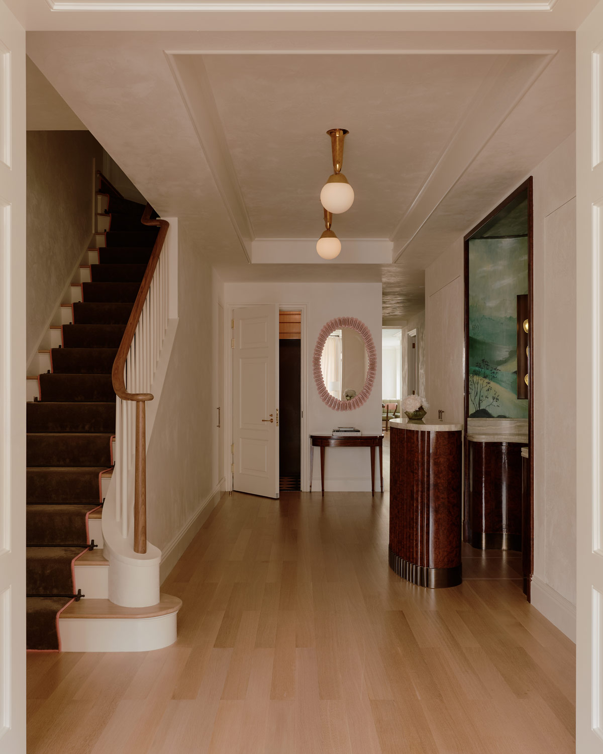Entry and stair hall with a retractable bar that moves on a track into a niche in a duplex apartment on New York's Park Avenue designer by Bryan O'Sullivan