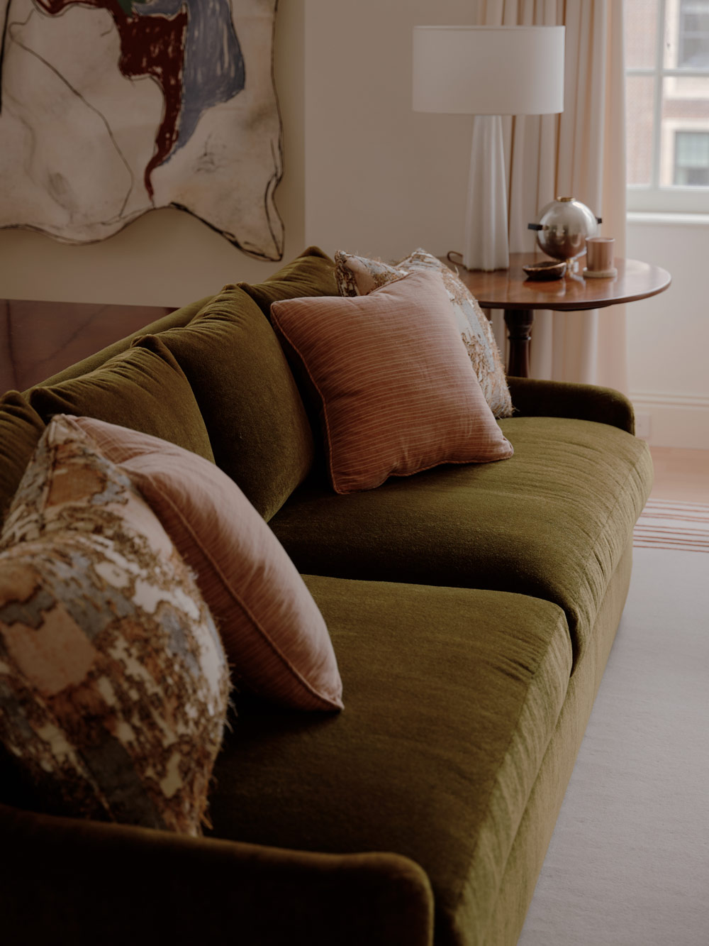 Green sofa in the living room of a duplex apartment on New York's Park Avenue designer by Bryan O'Sullivan