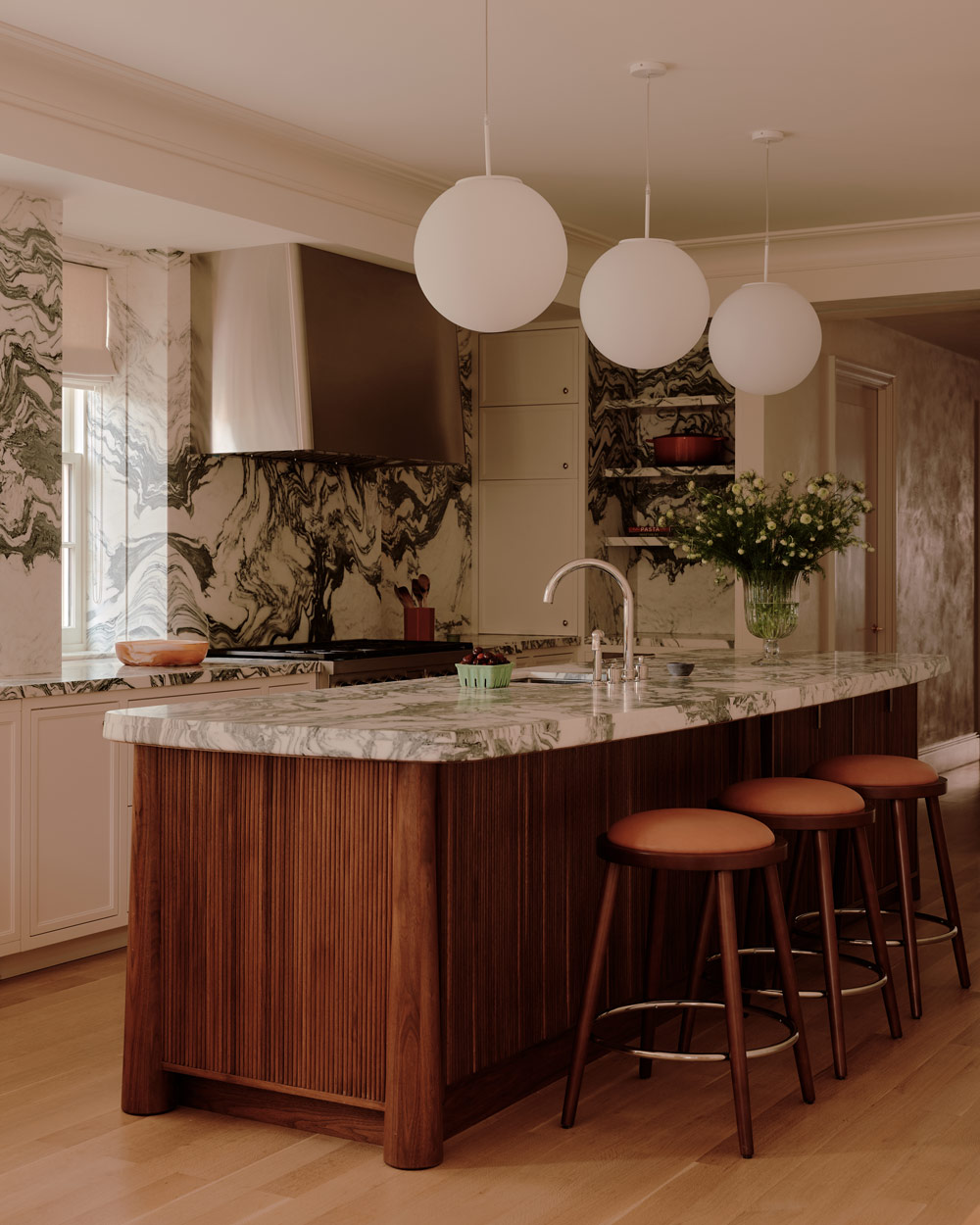 Kitchen with highly veined gray and white marble on the walls, shelves and counters in a duplex apartment on New York's Park Avenue designer by Bryan O'Sullivan