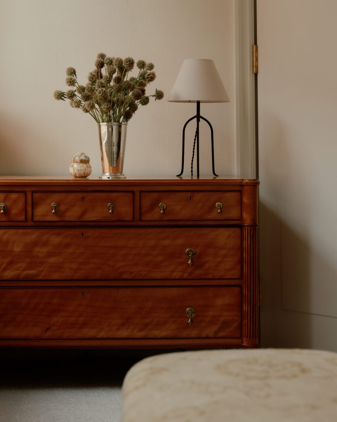 a late-19th-century satinwood English chest of drawers in the primary bedroom of a duplex apartment on New York's Park Avenue designer by Bryan O'Sullivan