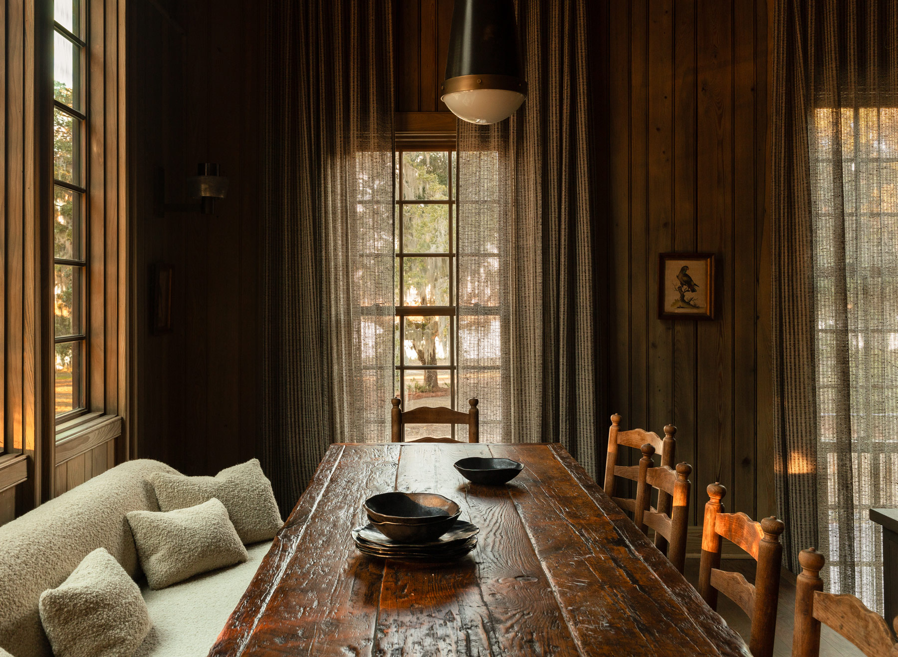 Dining area in the high-ceilinged barn-like great room of a former agrarian building on South Carolina's Edisto Island reimagined as a vacation home by interior designer Sean Anderson and architect Will Wingfield