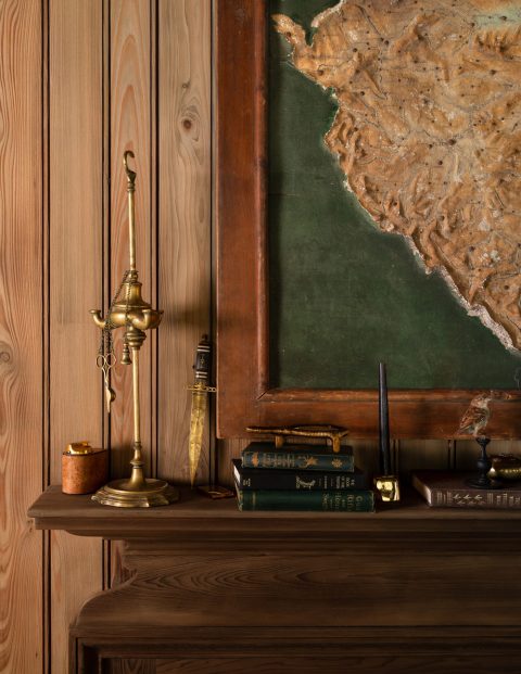 Map hung over mantel in great room of a former agrarian building on South Carolina's Edisto Island reimagined by interior designer Sean Anderson and architect Will Wingfield