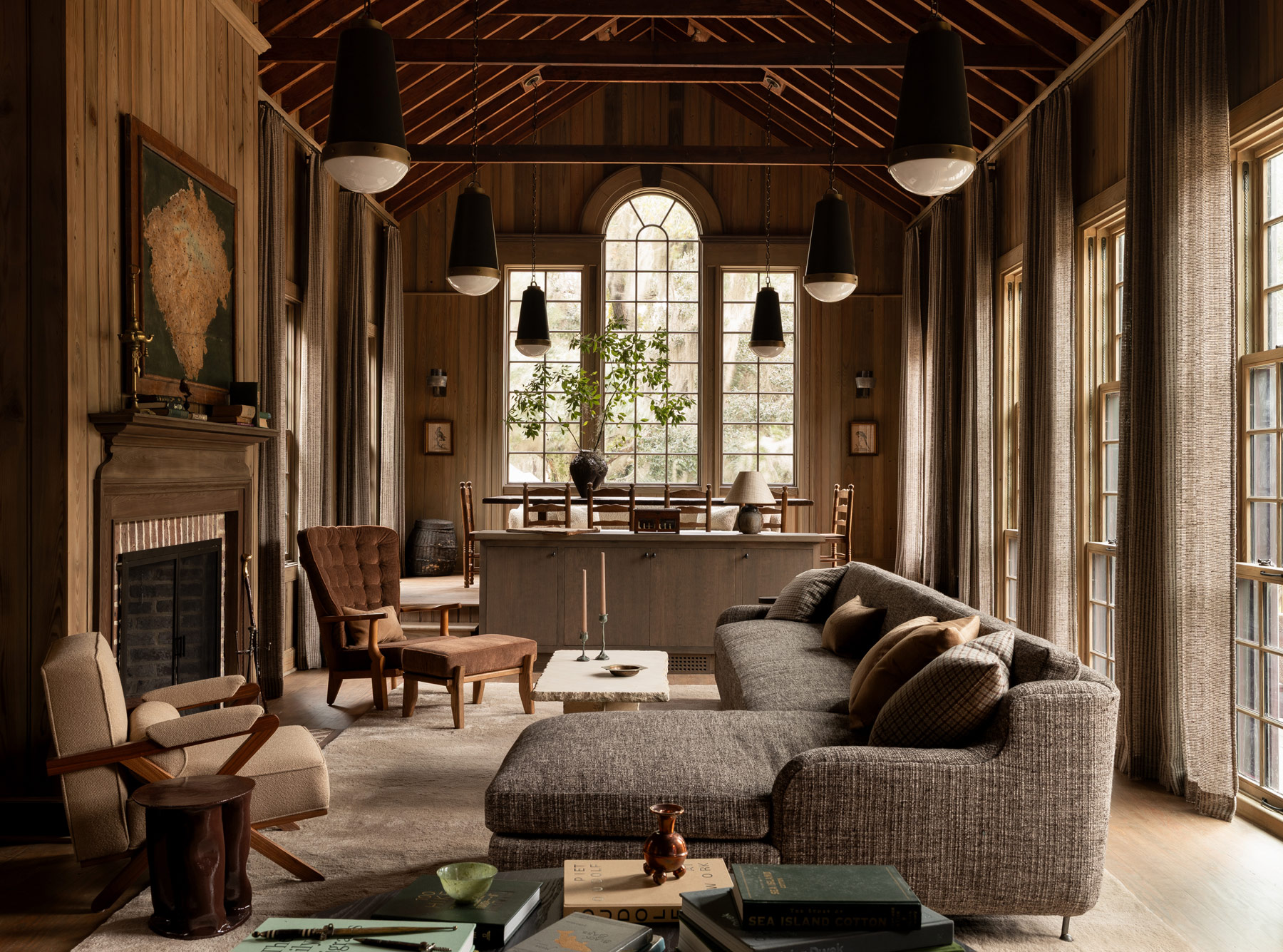 High-ceilinged barn-like beamed great room with living and dining area in a former agrarian building on South Carolina's Edisto Island reimagined by interior designer Sean Anderson and architect Will Wingfield