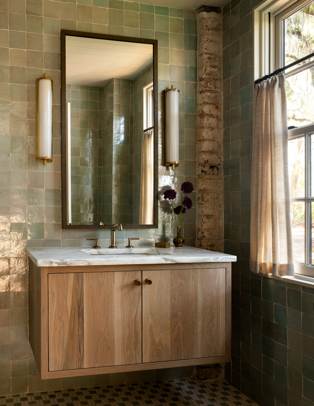 Guest bathroom with marble-topped wood vanity and pale-green zeligge-tiled walls in a former agrarian building on South Carolina's Edisto Island reimagined as a vacation home by interior designer Sean Anderson and architect Will Wingfield