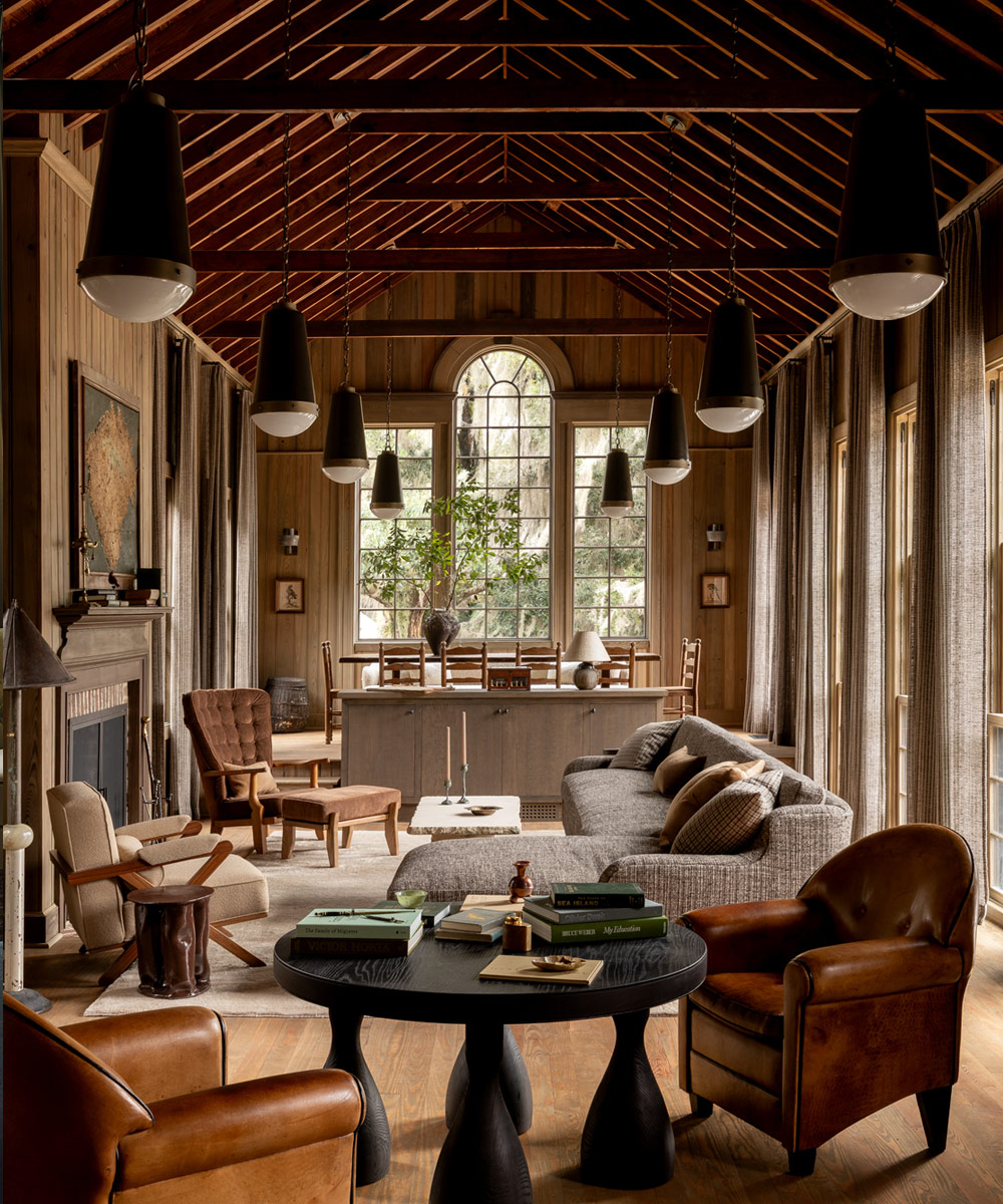 High-ceilinged barn-like beamed great room with living and dining area in a former agrarian building on South Carolina's Edisto Island reimagined by interior designer Sean Anderson and architect Will Wingfield